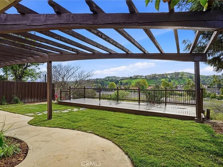 Back yard with a wooden pergola over a raised deck overlooking the Simi Hills